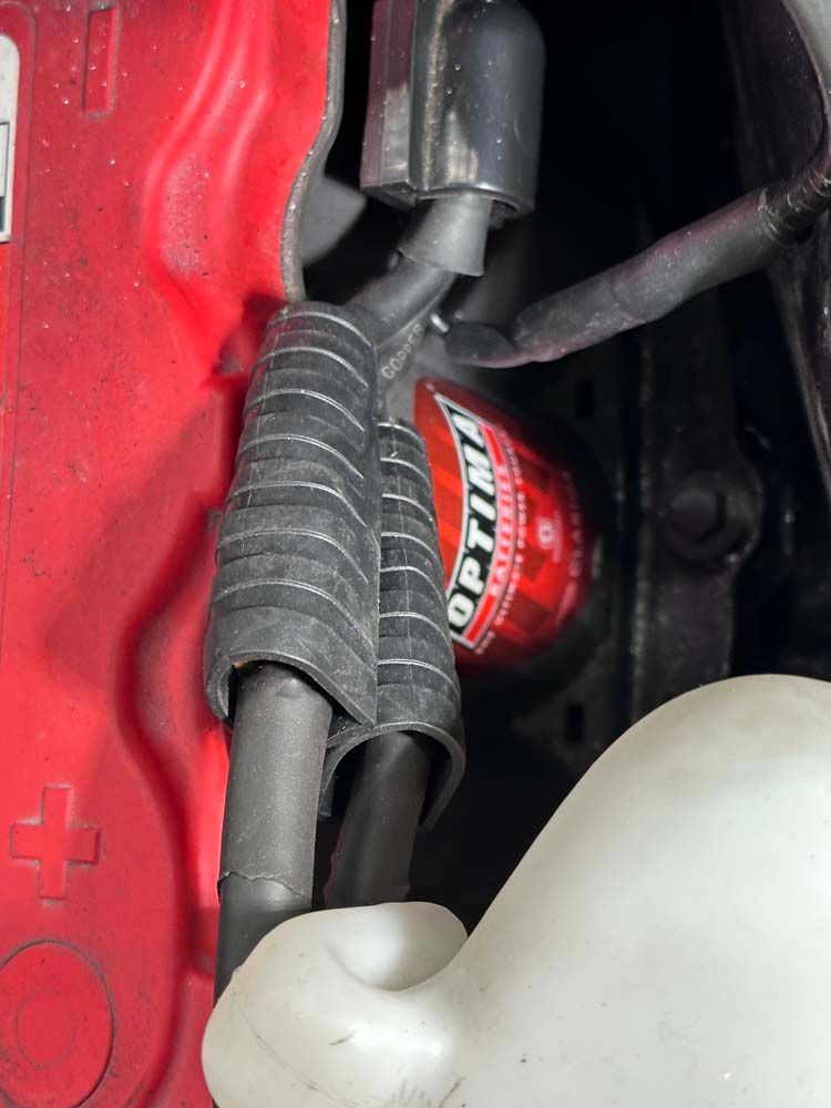 A close up of a red car with a red optima spark plug