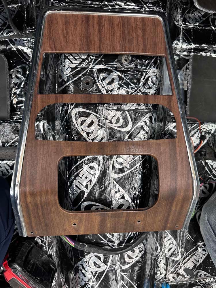 A wooden dashboard is sitting on top of a black and white carpet.