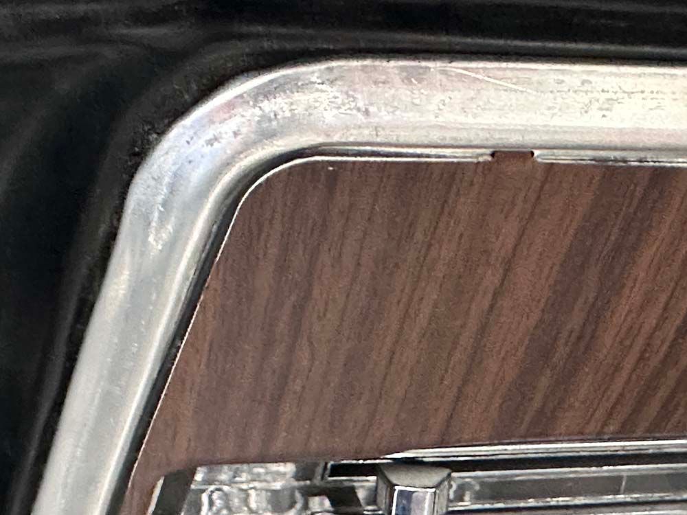 A close up of a wooden dashboard on a car.