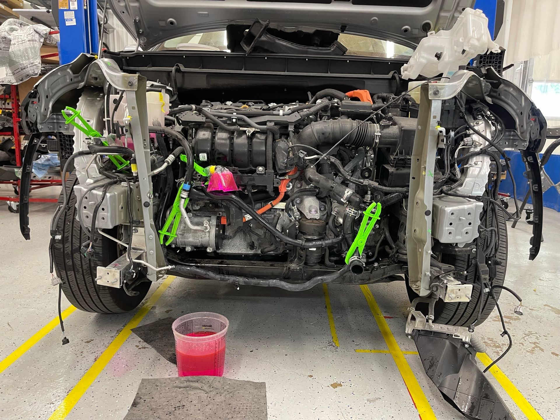 The engine of a car is being worked on in a garage.