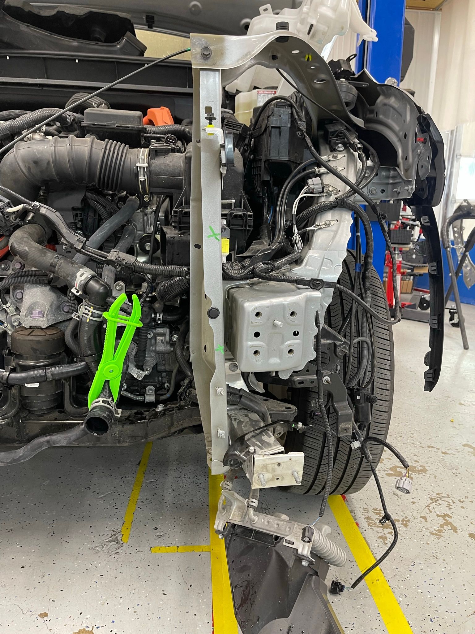 A car is being dismantled in a garage.