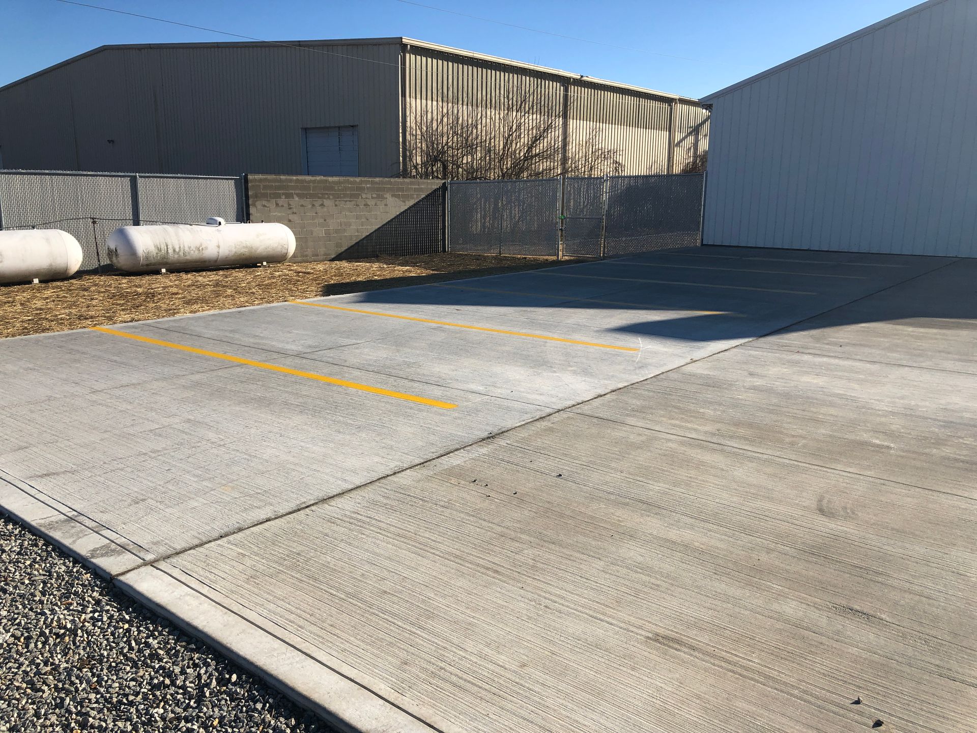 A concrete parking lot with a white building in the background.