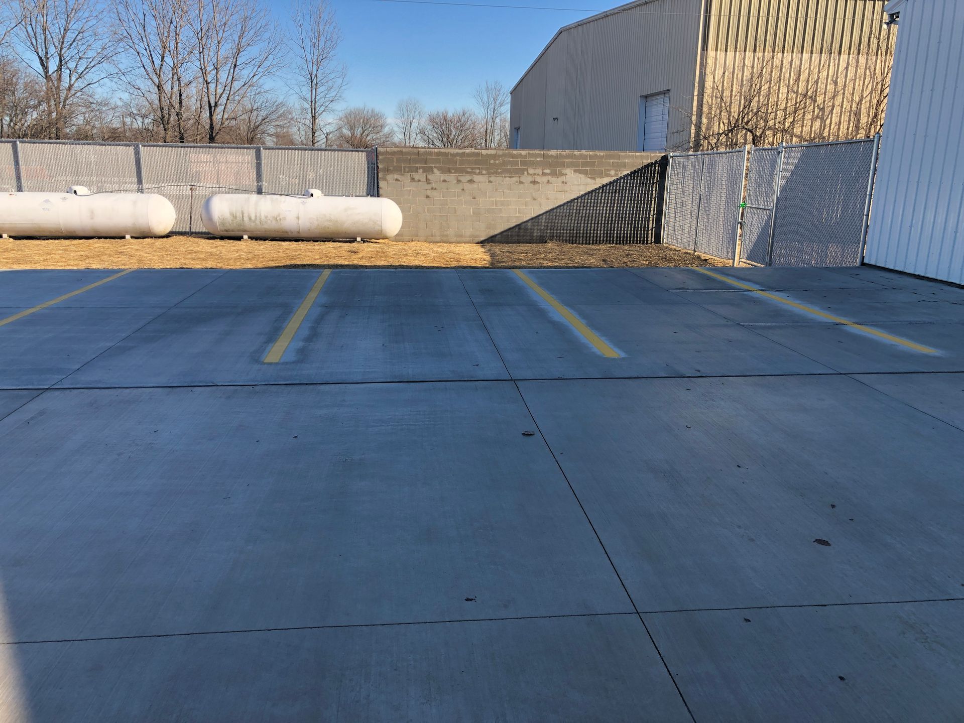 A parking lot with propane tanks in it and a building in the background.
