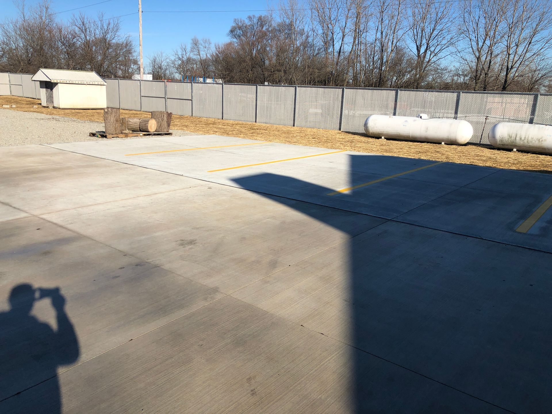 A person is taking a picture of a parking lot with propane tanks.