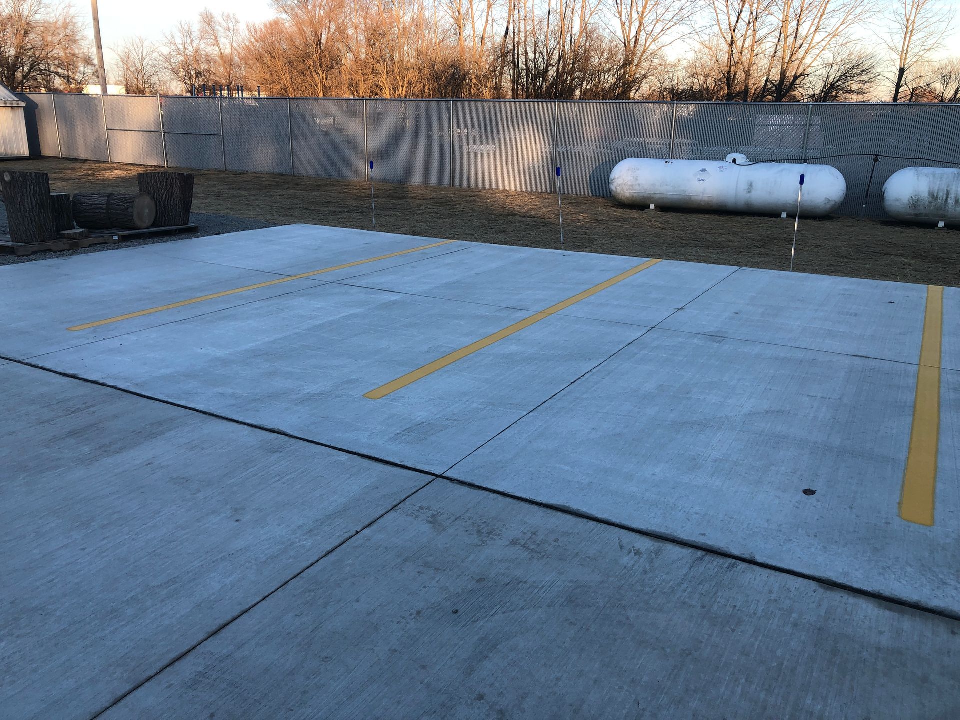 A parking lot with propane tanks in the background.