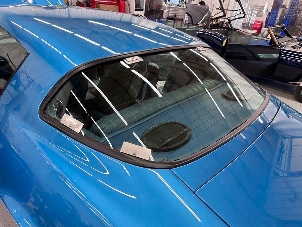A close up of a blue car 's windshield in a garage