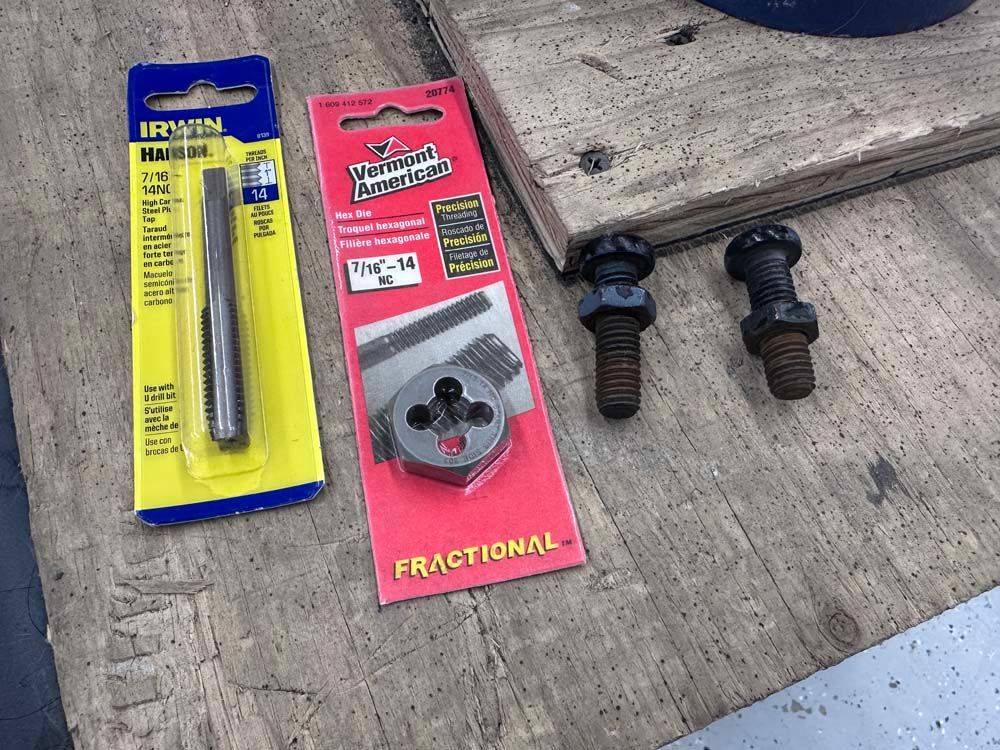 A bunch of tools are sitting on a wooden table.