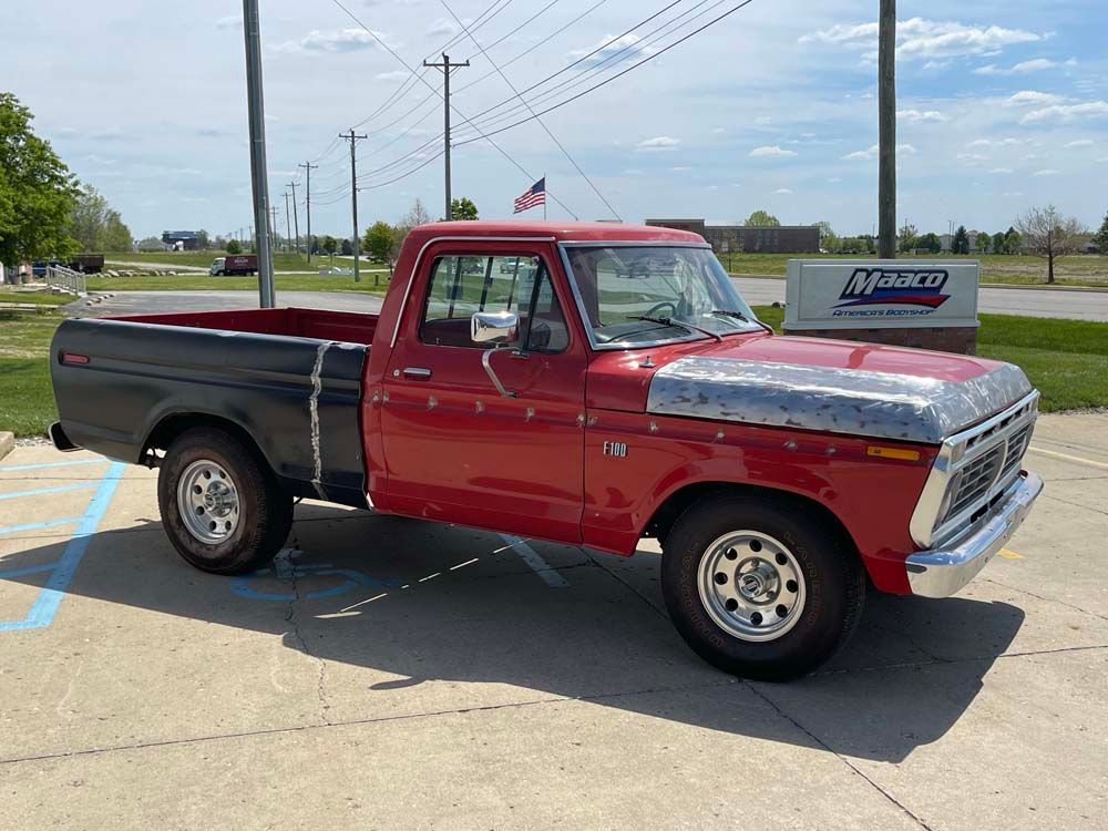 A red and black pickup truck is parked in a parking lot.