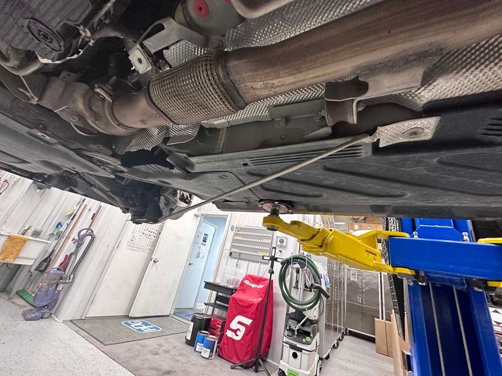 A car is sitting on a lift in a garage.