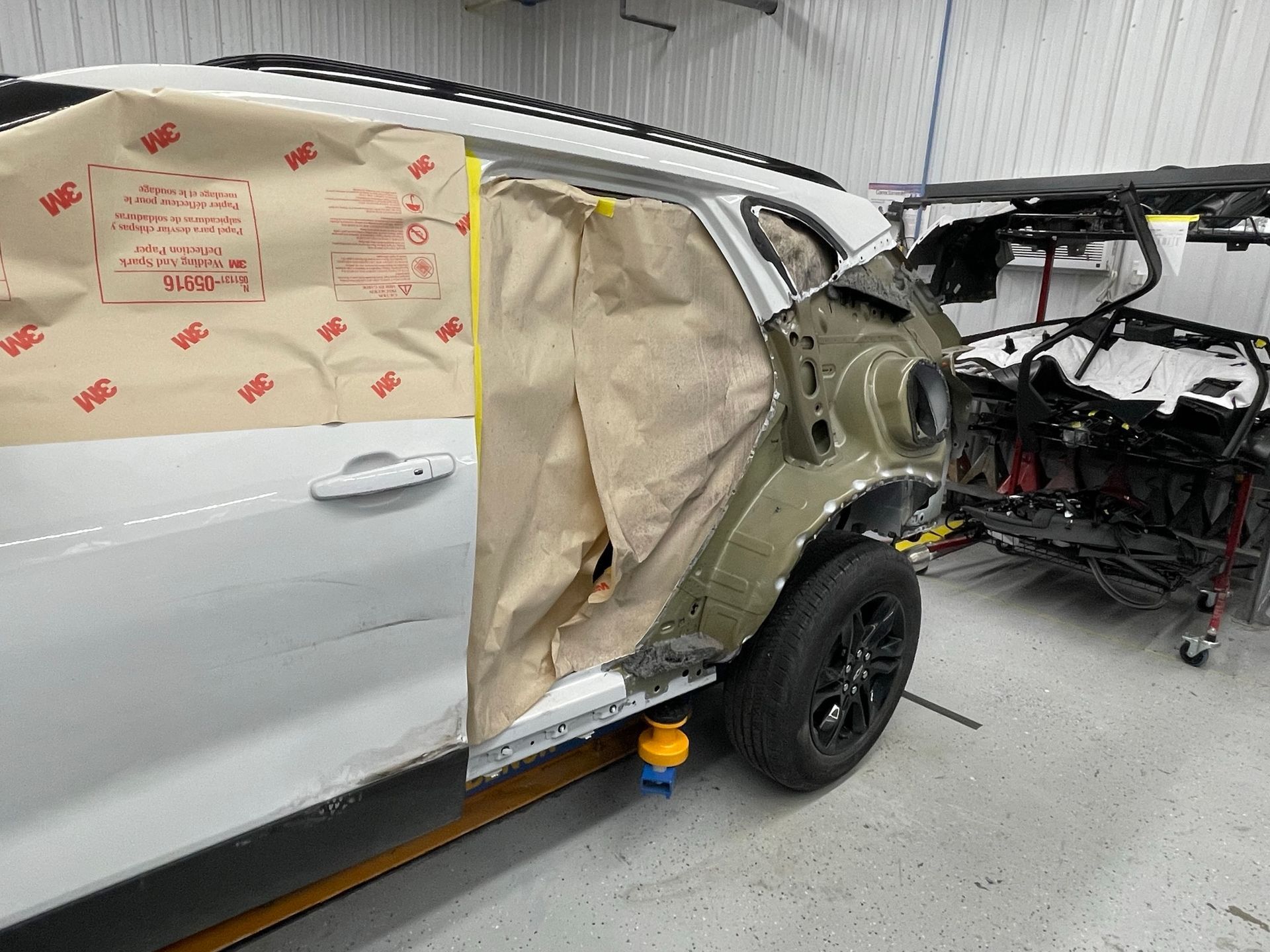 A car is being painted in a garage.