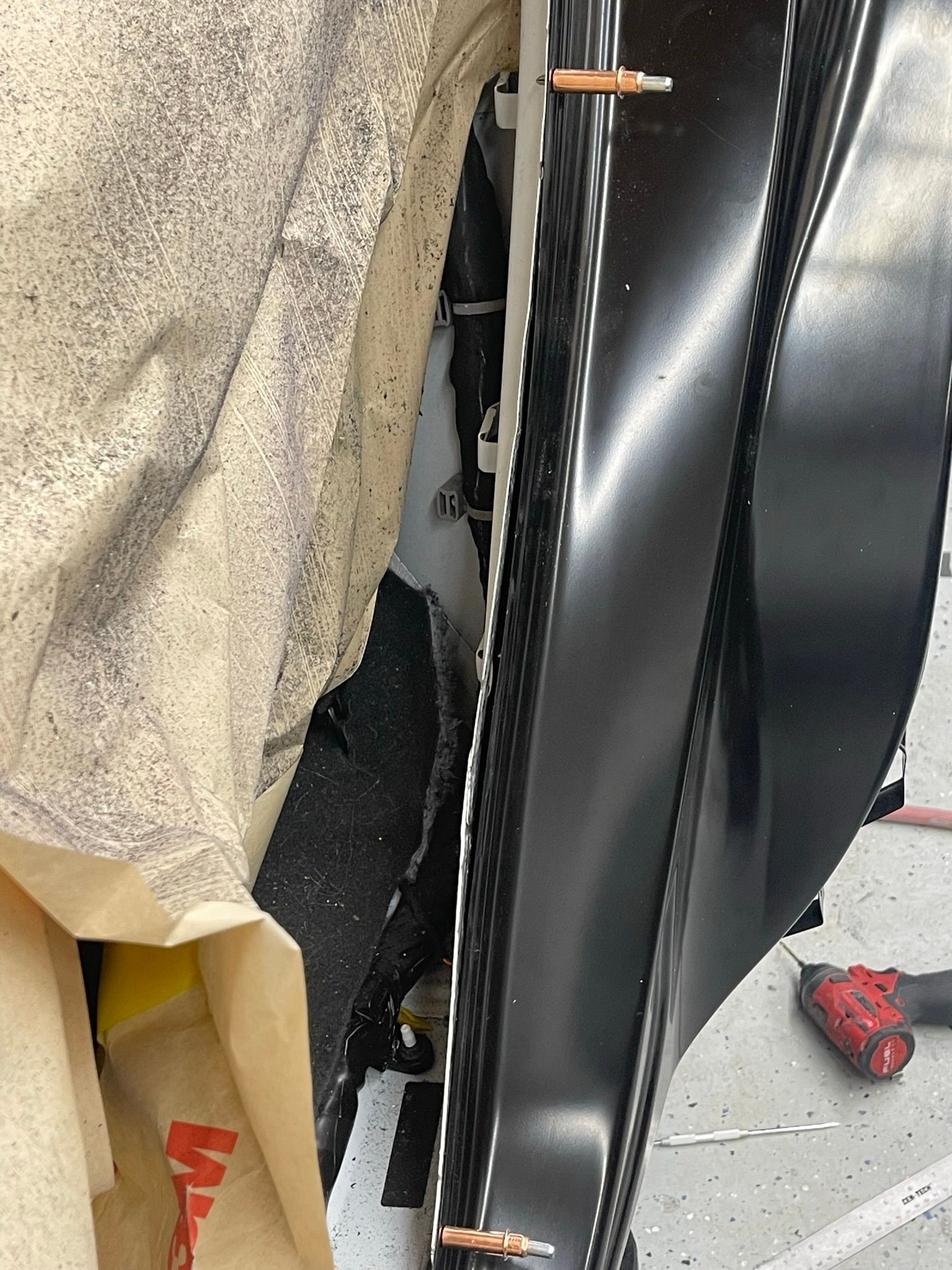 A person is working on a piece of metal in a garage.