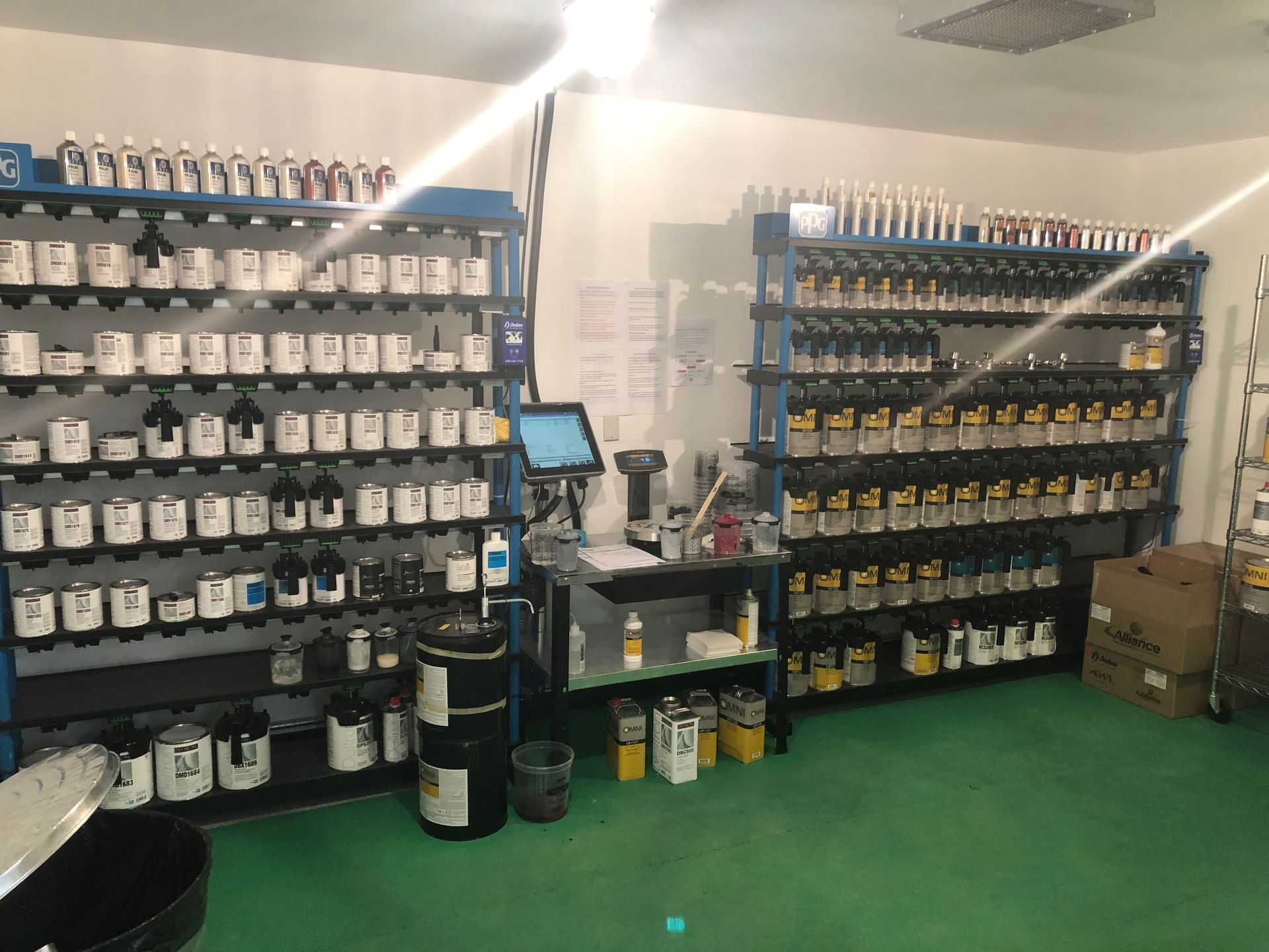 A room filled with lots of bottles of paint on shelves.