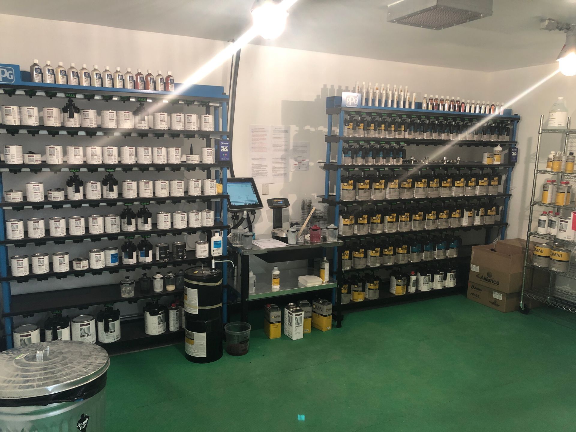 A room filled with lots of shelves and bottles of paint.