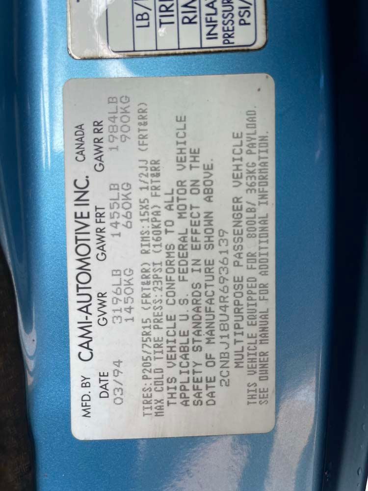 A blue car with a white label that says caml automotive inc