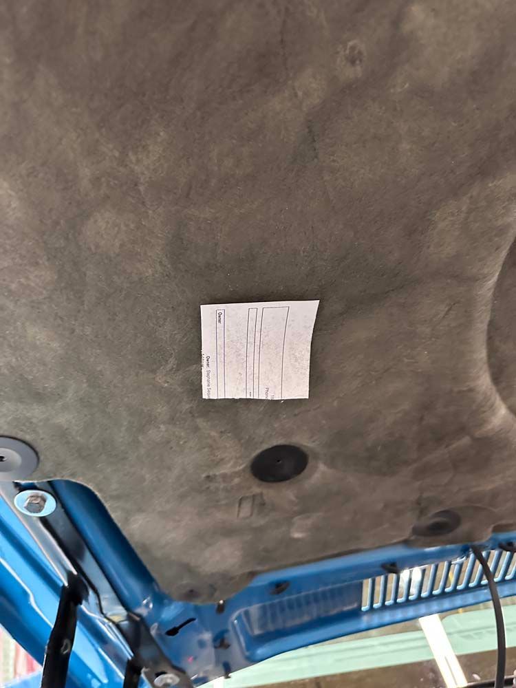 A piece of paper is hanging from the ceiling of a car.