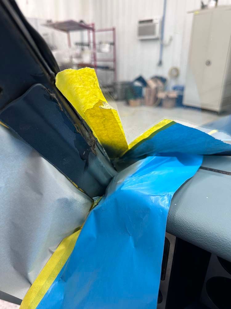 A close up of a blue and yellow tape on a car dashboard.