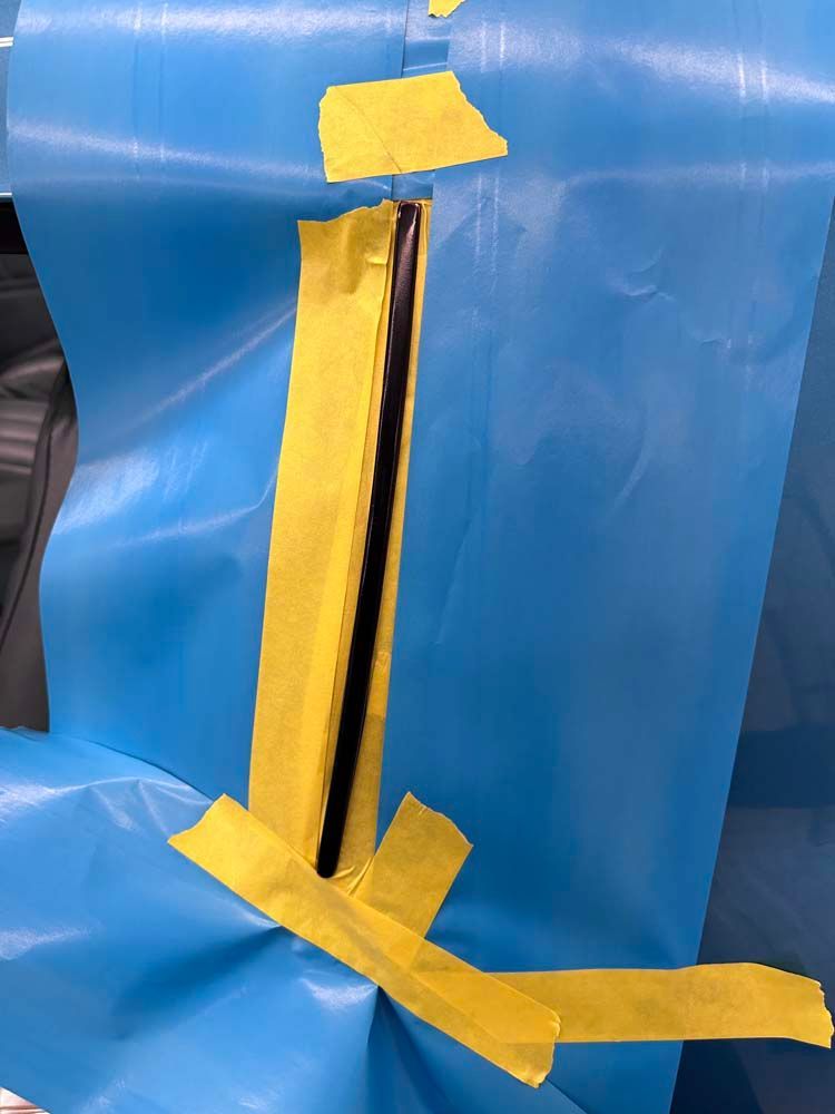 A piece of blue plastic with yellow tape on it