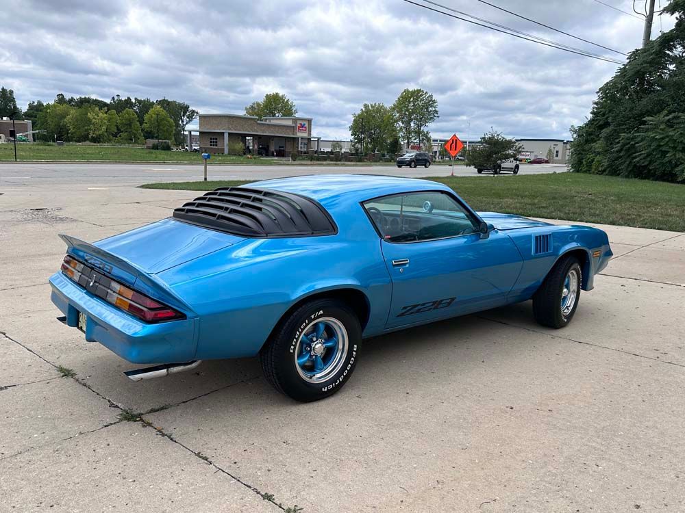 A blue car is parked on the side of the road.