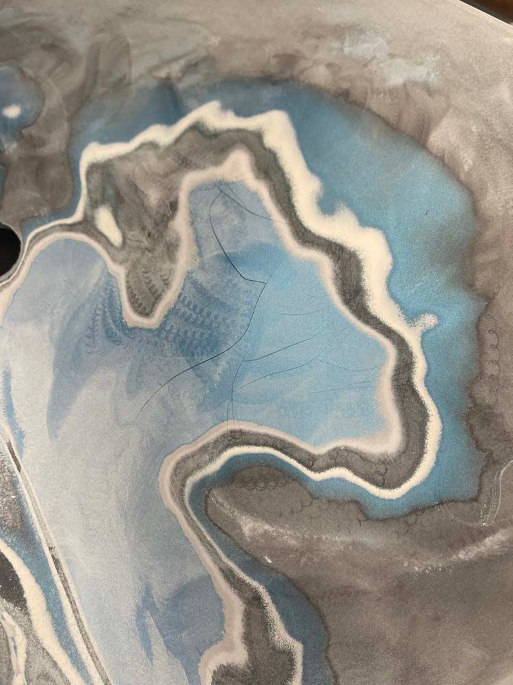 A close up of a blue and gray marble painting on a table.