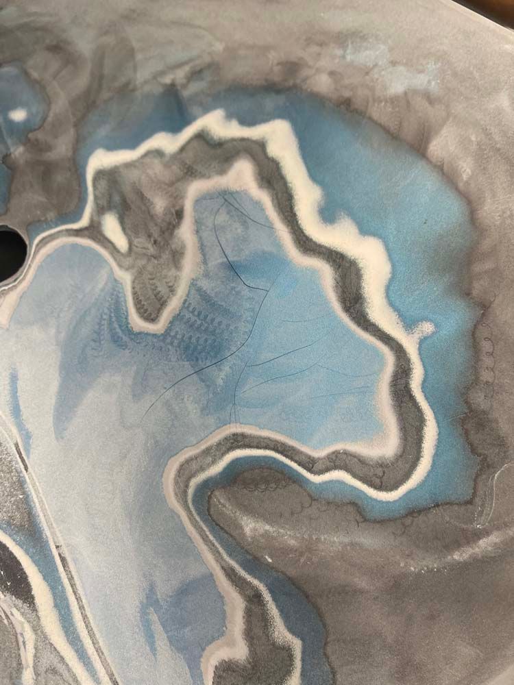 A close up of a blue and gray painting on a table.