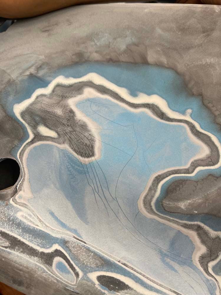 A close up of a painting of a lake with a hole in the middle.