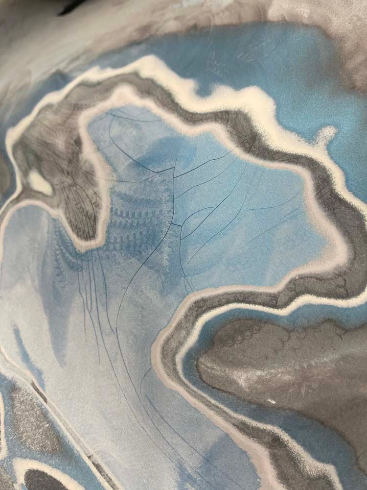 A close up of a blue and gray marble painting on a wall.