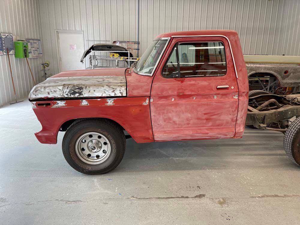 A red truck is parked in a garage.