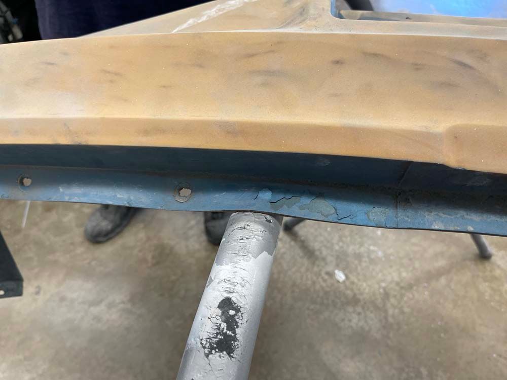 A piece of wood is sitting on top of a metal pipe.