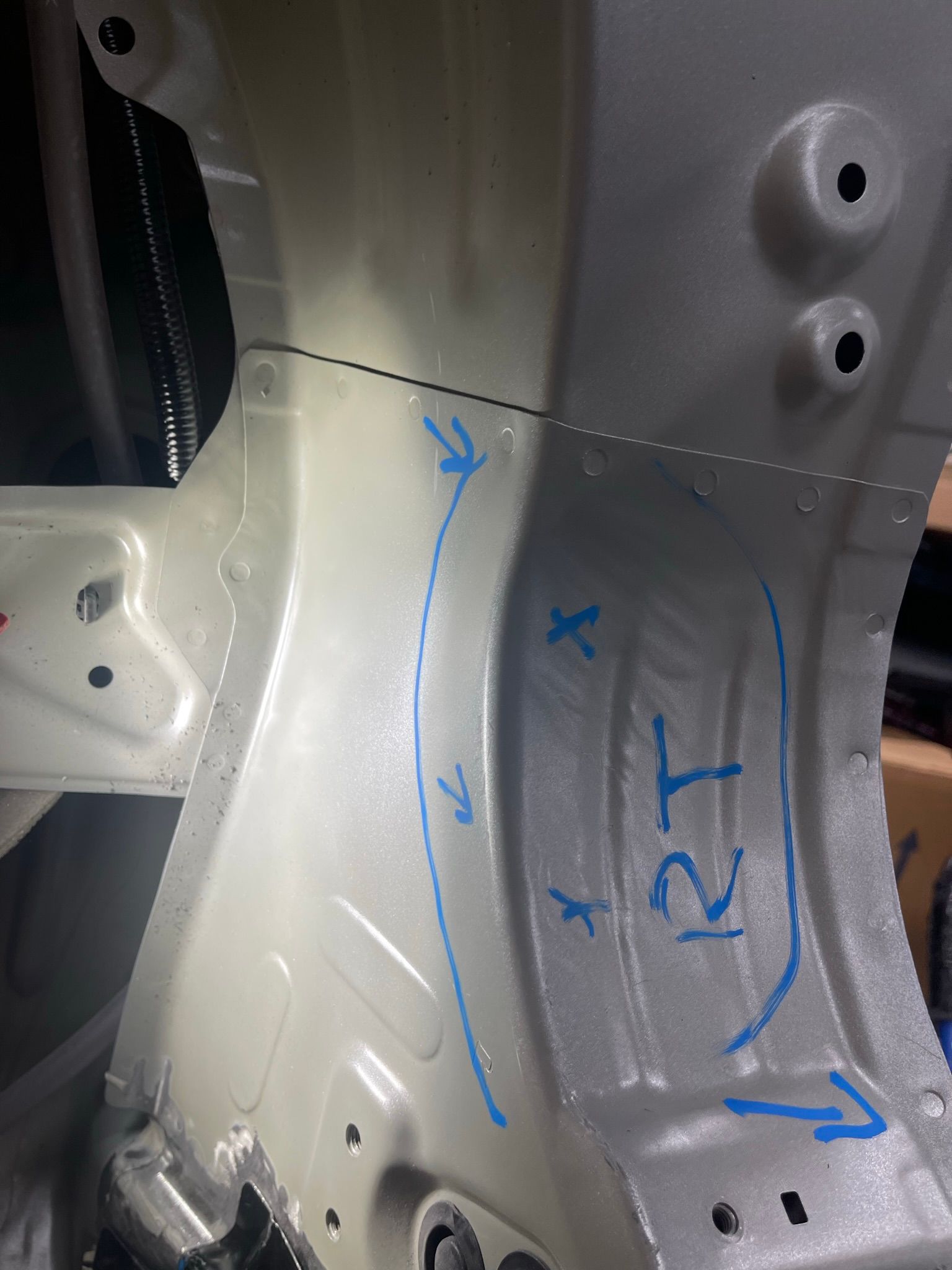 A close up of a piece of metal with blue markings on it.