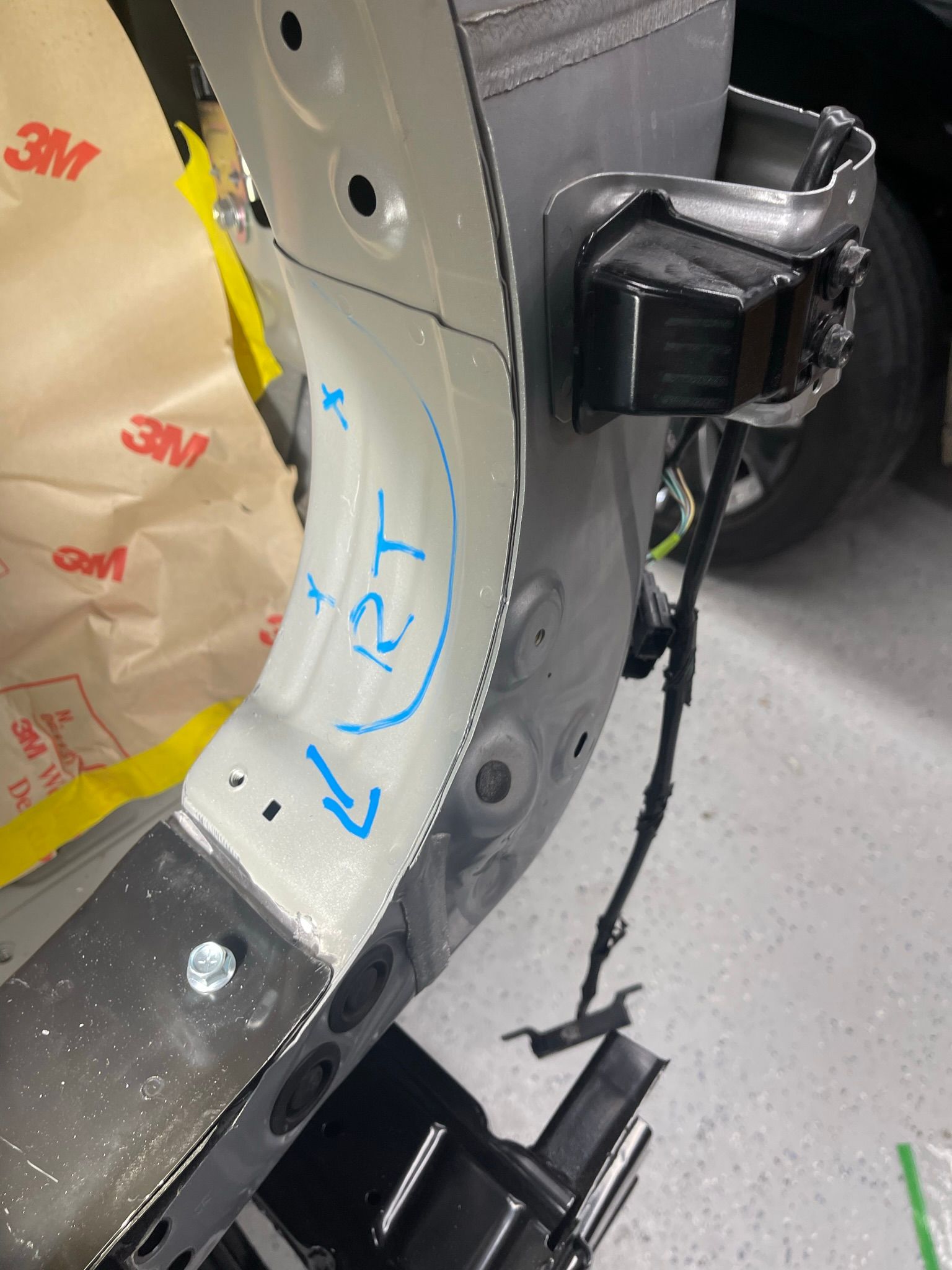 A close up of a car bumper with a blue marker on it.