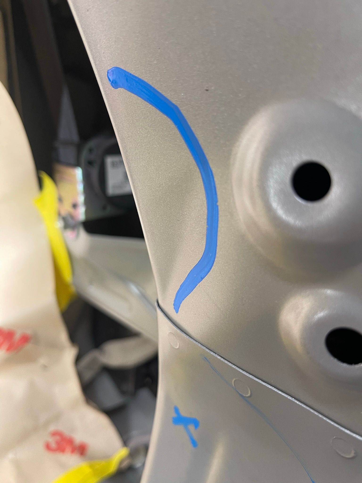 A close up of a piece of metal with a blue x on it.