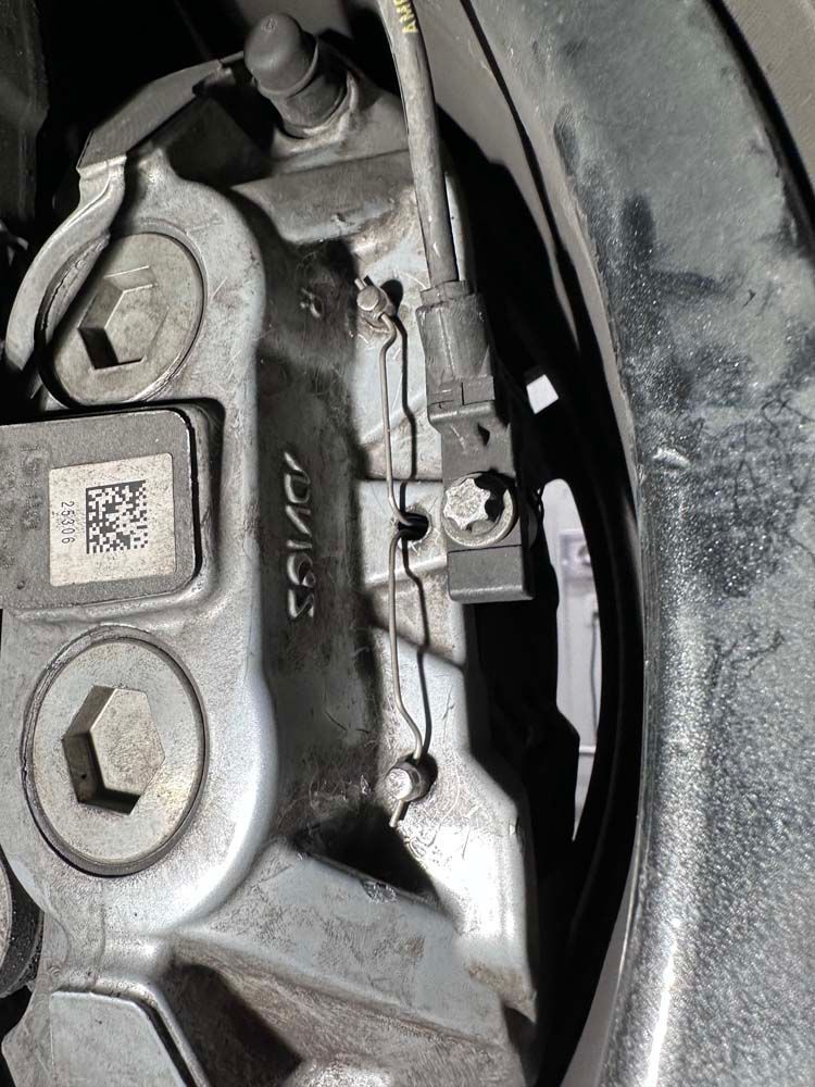 A close up of a brake caliper on a car.