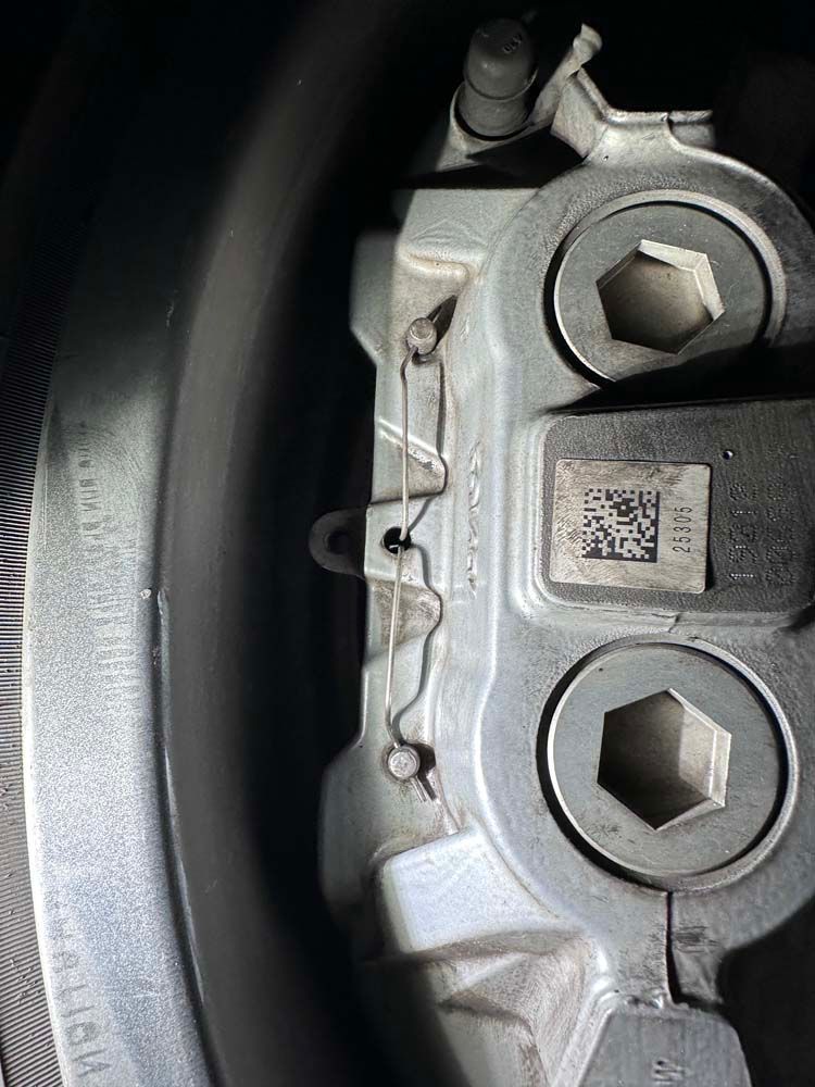 A close up of a brake caliper on a car wheel.
