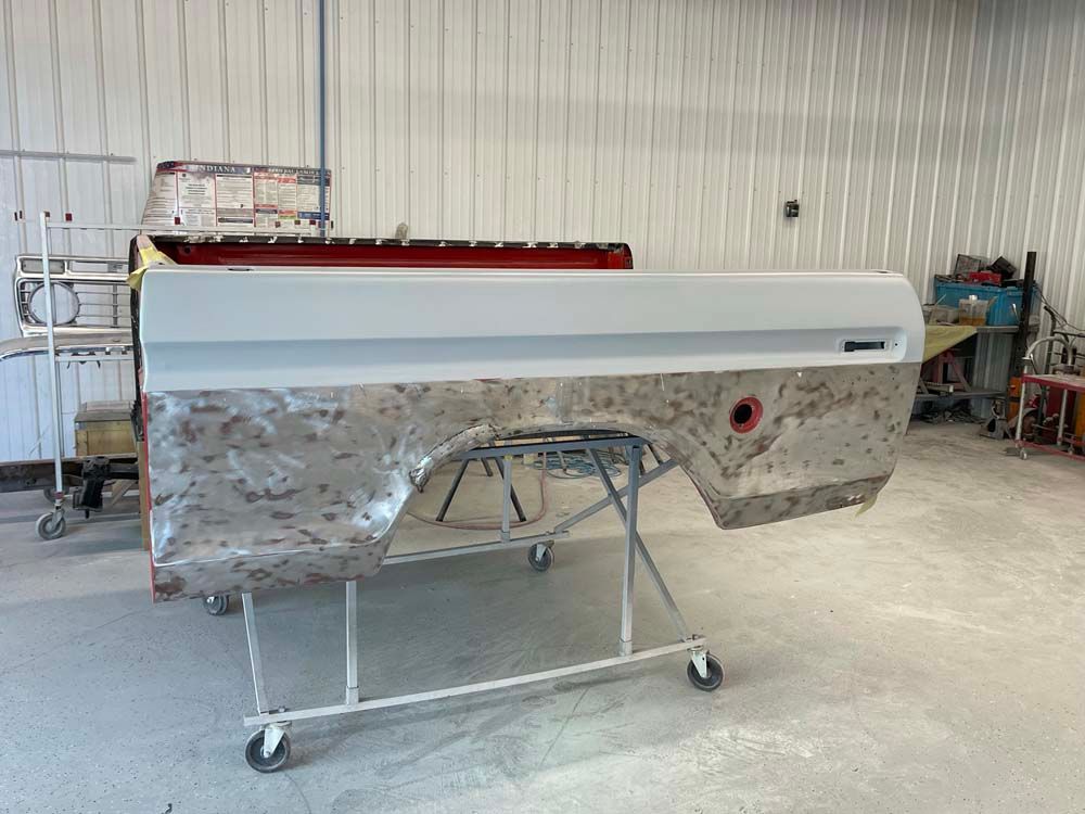 A truck bed is sitting on a rack in a garage.