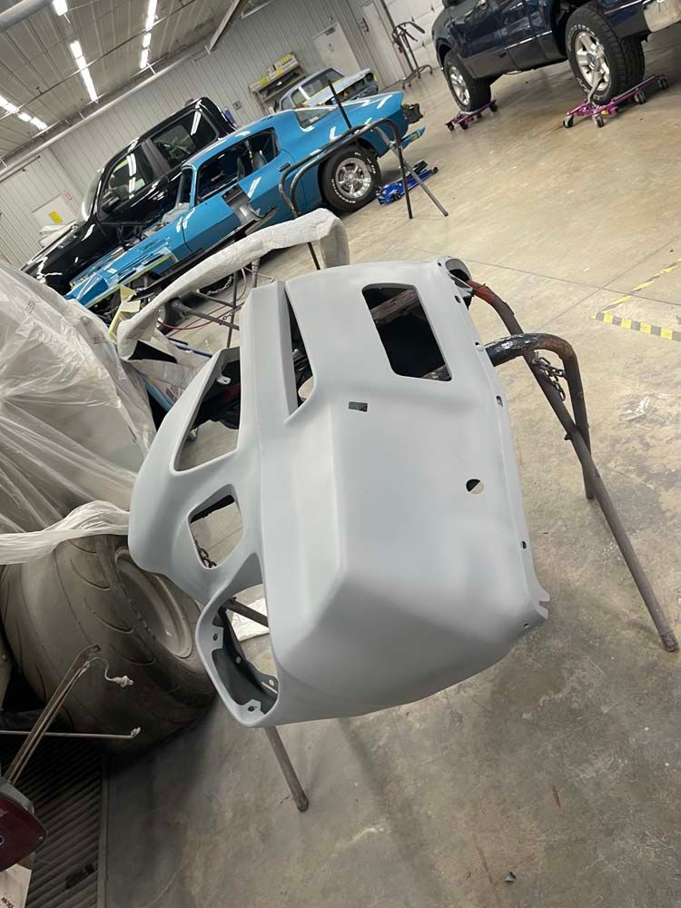 A car is being painted in a garage.