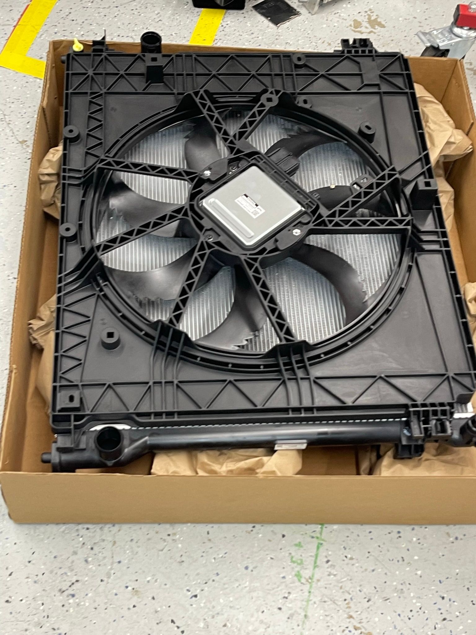 A radiator fan is sitting in a cardboard box.