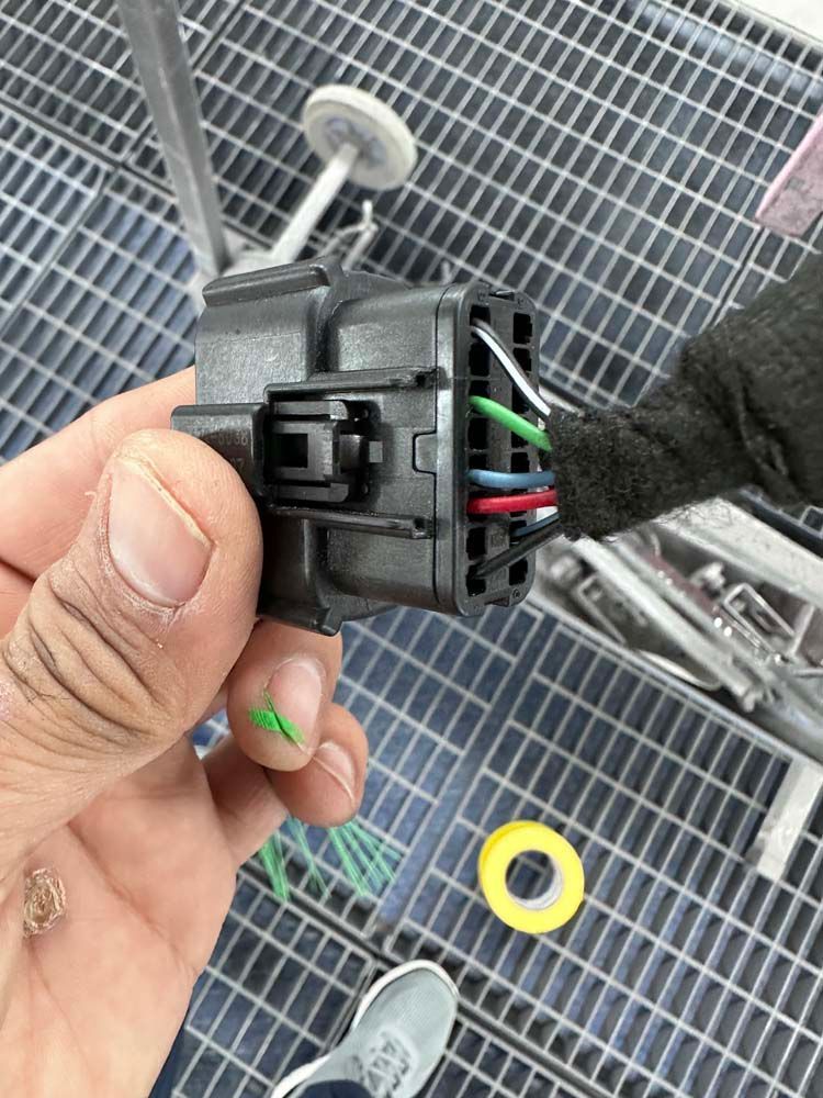 A person is holding a connector in their hand.