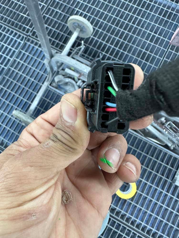 A person is holding a connector in their hand.