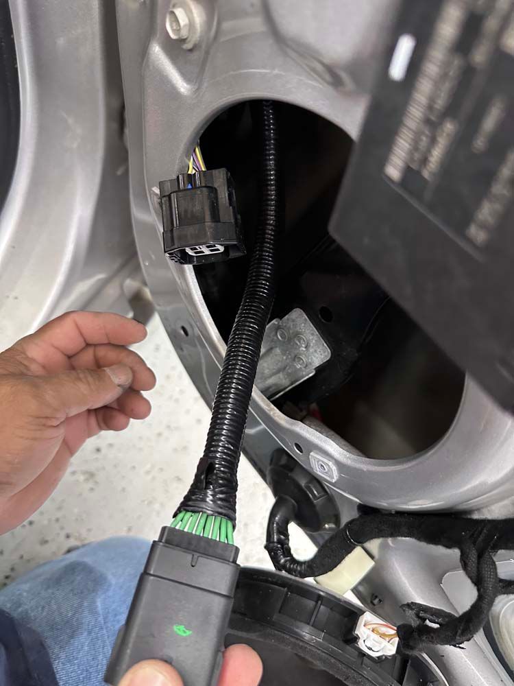 A person is holding a remote control in front of a car door.