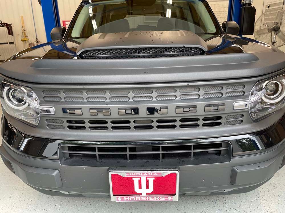 The front of a black bronco with a red license plate