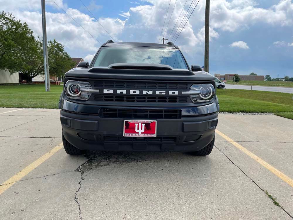 A black ford bronco is parked in a parking lot.