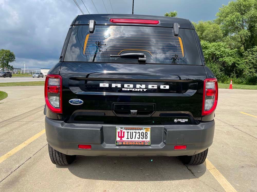 A black ford bronco is parked in a parking lot.