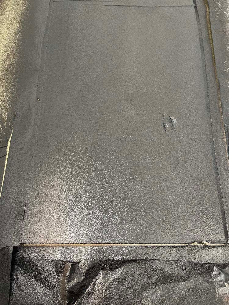 A close up of a metal surface with a hole in it.