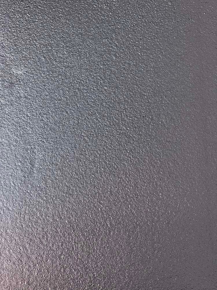 A close up of a metal surface with a metallic texture.