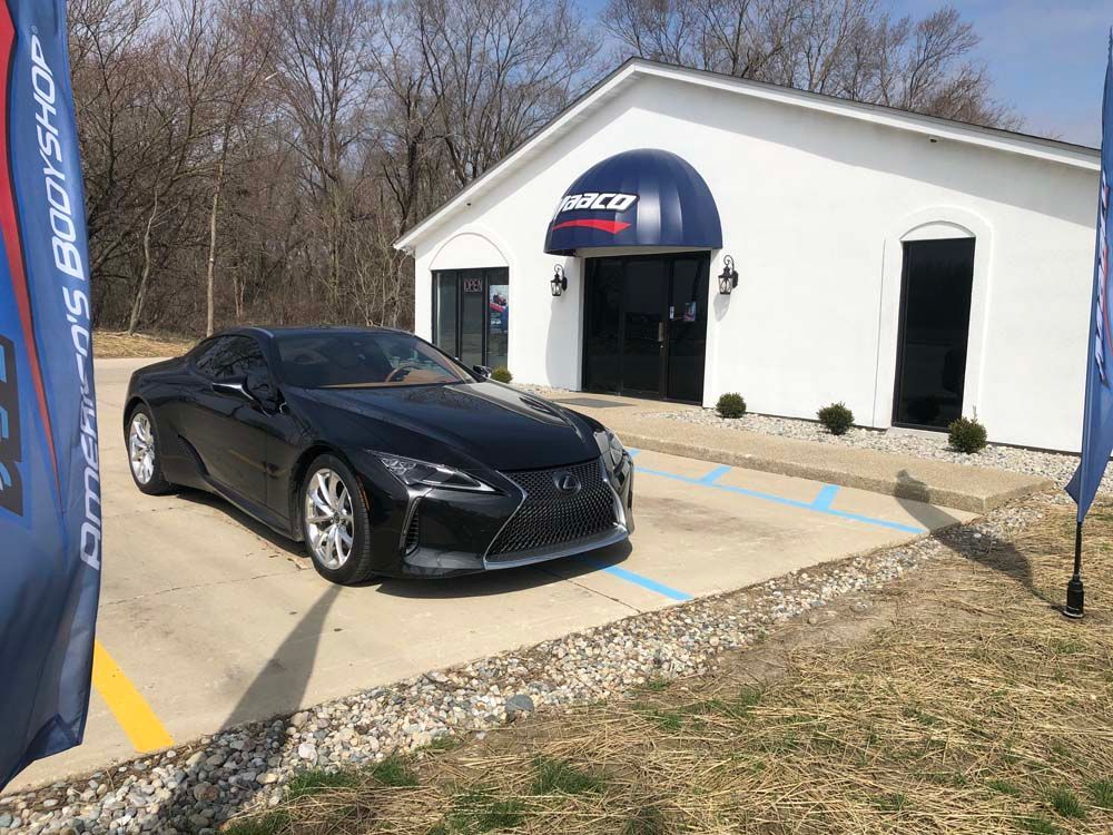A black sports car is parked in front of a building.