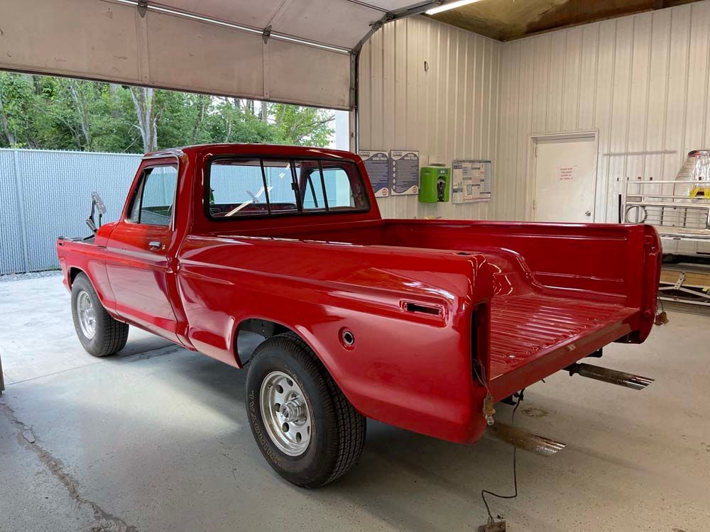 A red pickup truck is parked in a garage.