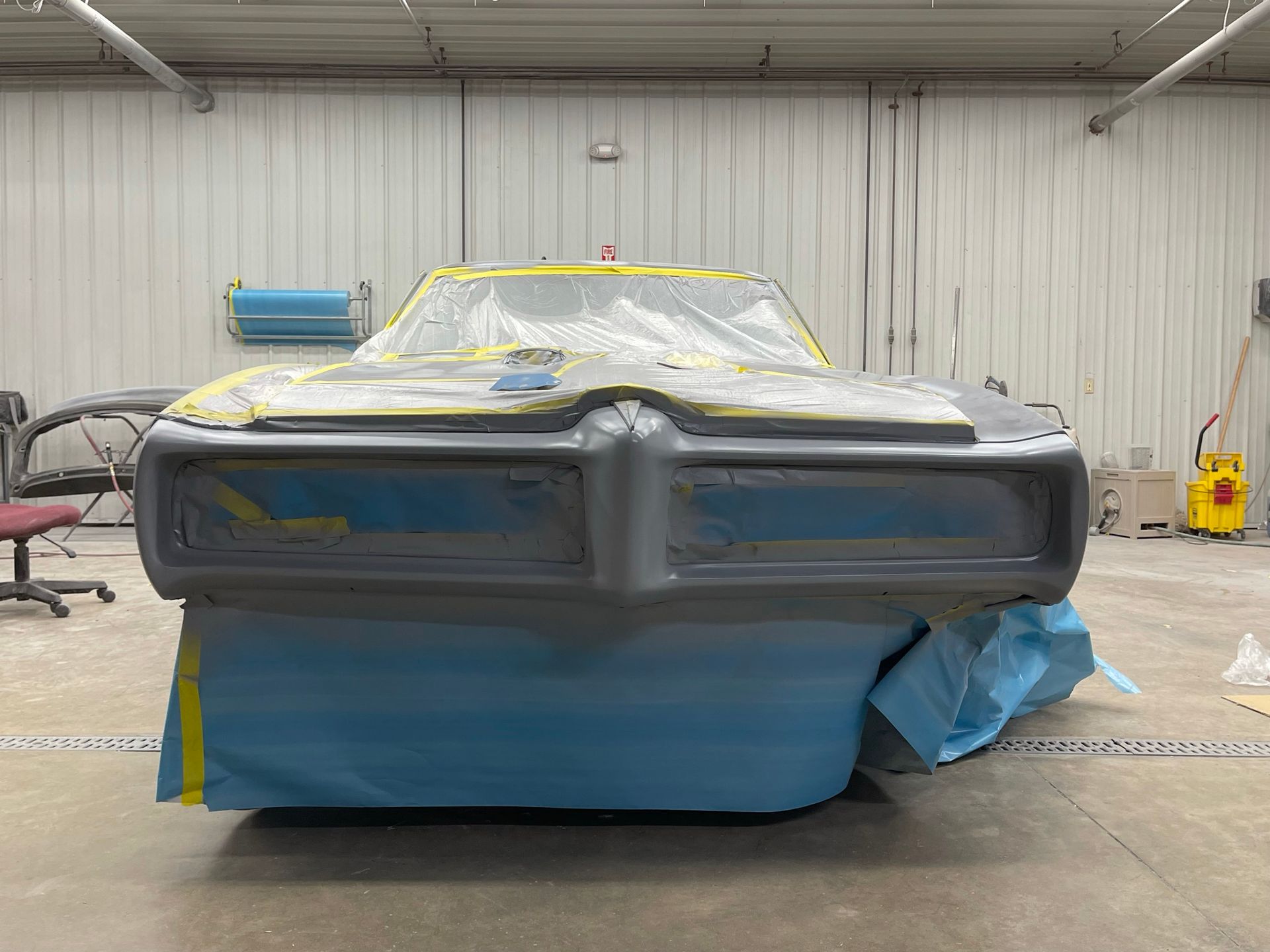 A car is being painted in a garage.