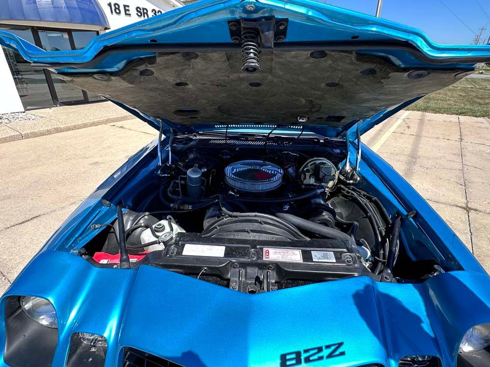 The engine of a blue car with the hood open