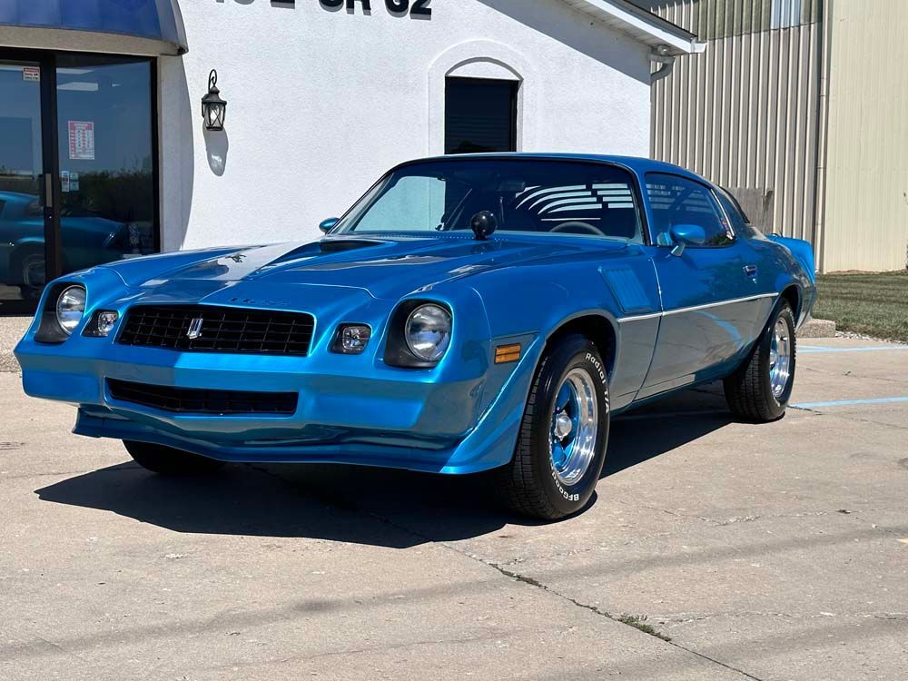 A blue car is parked in front of a building.