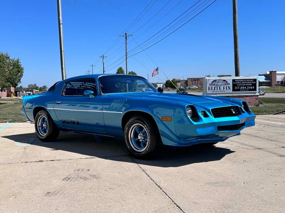 A blue car is parked on the side of the road.